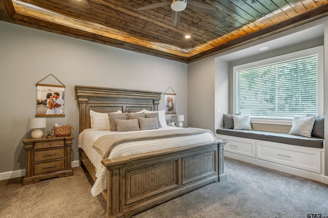 carpeted bedroom with ceiling fan, wood ceiling, and a raised ceiling