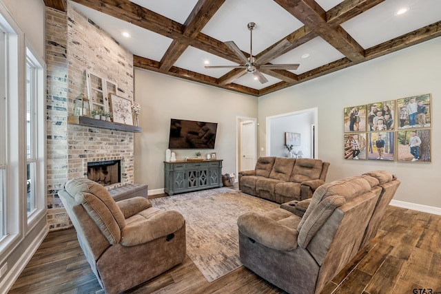 living room with dark hardwood / wood-style flooring, a fireplace, coffered ceiling, and beamed ceiling