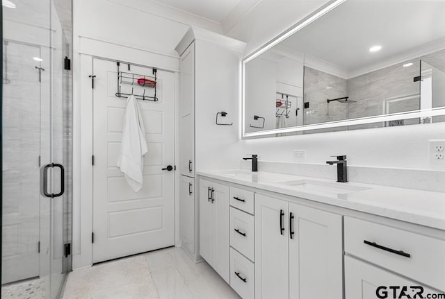 bathroom with double vanity, marble finish floor, a shower stall, and a sink