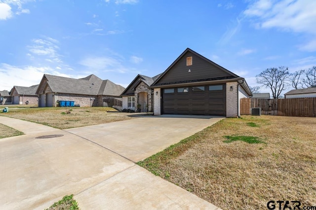 view of front of house featuring a front lawn, driveway, fence, a garage, and brick siding