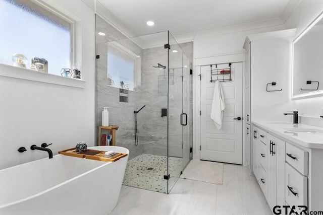 bathroom with vanity, ornamental molding, a freestanding bath, a shower stall, and marble finish floor