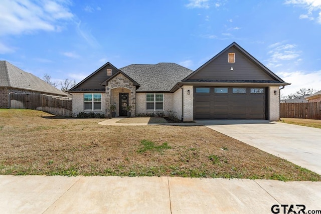 view of front of property with fence, driveway, a front lawn, a garage, and brick siding