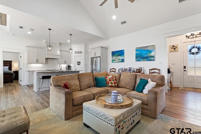 living room featuring visible vents, ceiling fan, light wood-type flooring, recessed lighting, and high vaulted ceiling