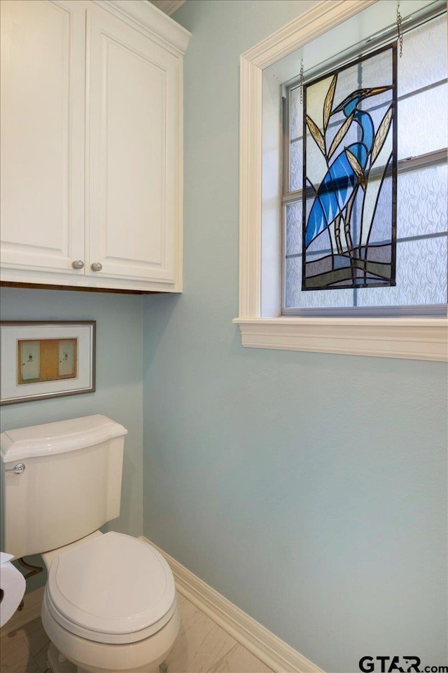 909 Univerity Dr, Carthage, TX 75633 - bathroom featuring baseboards and toilet
