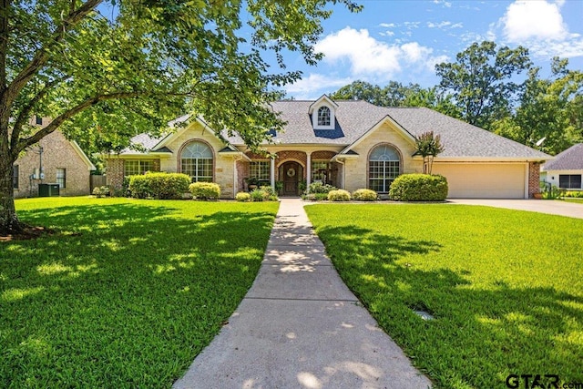 909 Univerity Dr, Carthage, TX 75633 - view of front facade with a garage, a front lawn, stone siding, and concrete driveway
