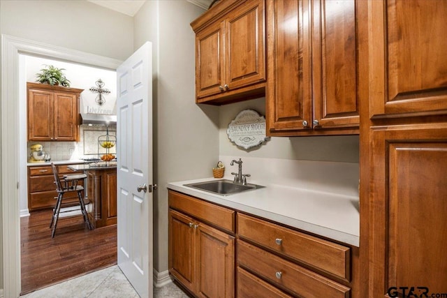 909 Univerity Dr, Carthage, TX 75633 - kitchen featuring a sink, extractor fan, tasteful backsplash, and brown cabinets