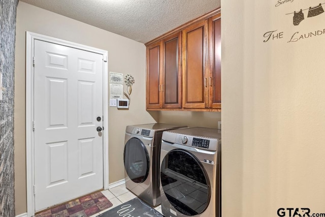 washroom with washer and clothes dryer, light tile patterned flooring, cabinets, and a textured ceiling