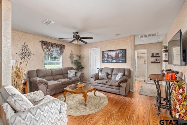 living room featuring ceiling fan and light wood-type flooring