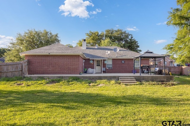 back of property with a gazebo, a yard, and a patio