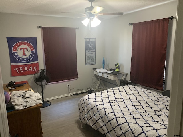 bedroom featuring wood-type flooring, a textured ceiling, and ceiling fan