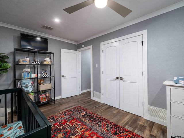 bedroom with ceiling fan, a closet, dark hardwood / wood-style flooring, and ornamental molding