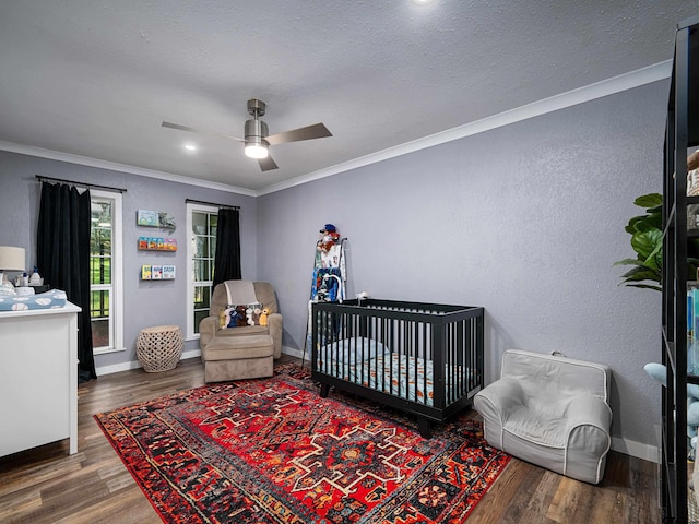 bedroom featuring dark wood-type flooring, ceiling fan, a textured ceiling, and ornamental molding