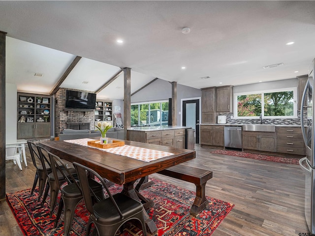 dining space featuring a wealth of natural light, sink, vaulted ceiling with beams, and dark hardwood / wood-style flooring