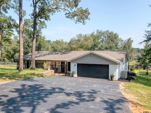 ranch-style house with central AC unit, a garage, and a front yard