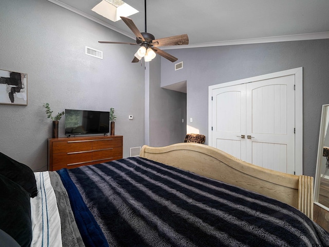 bedroom with ornamental molding, a closet, lofted ceiling with skylight, and ceiling fan