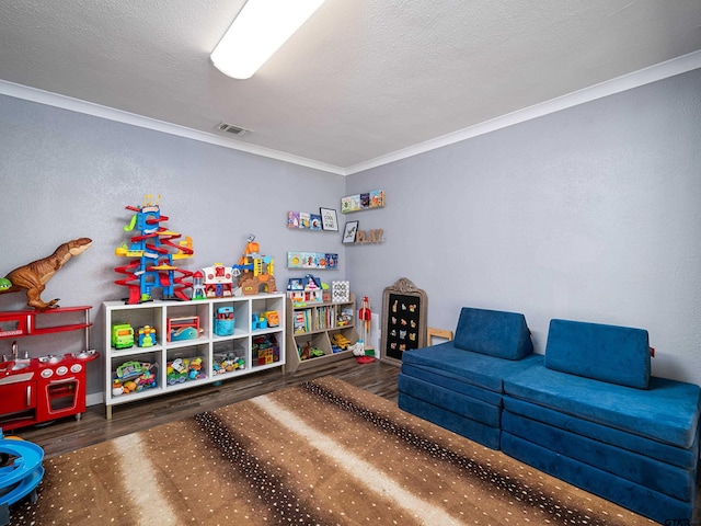 playroom with dark wood-type flooring, a textured ceiling, and crown molding