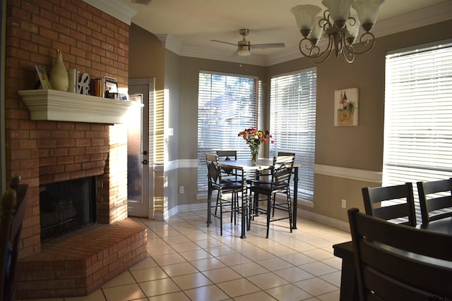 tiled dining space featuring a brick fireplace, ceiling fan with notable chandelier, and ornamental molding