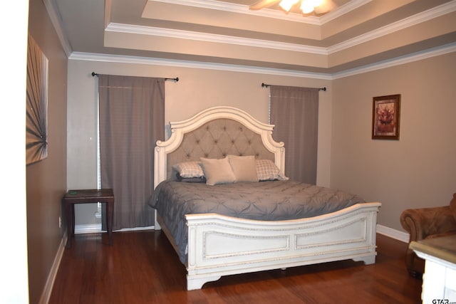 bedroom featuring ornamental molding, dark wood-type flooring, ceiling fan, and a raised ceiling