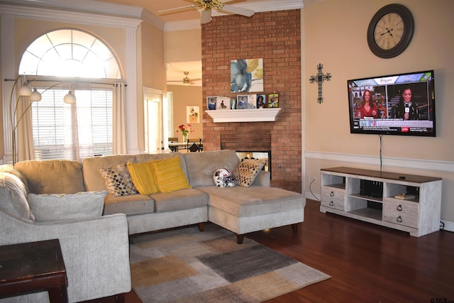 living room featuring ceiling fan, dark hardwood / wood-style floors, a brick fireplace, and ornamental molding