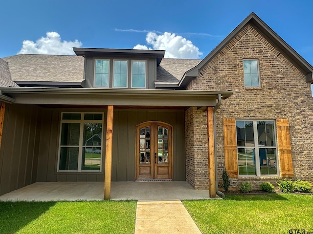 12301 Harlon, Flint, TX 75762 - doorway to property with roof with shingles, brick siding, board and batten siding, and a lawn