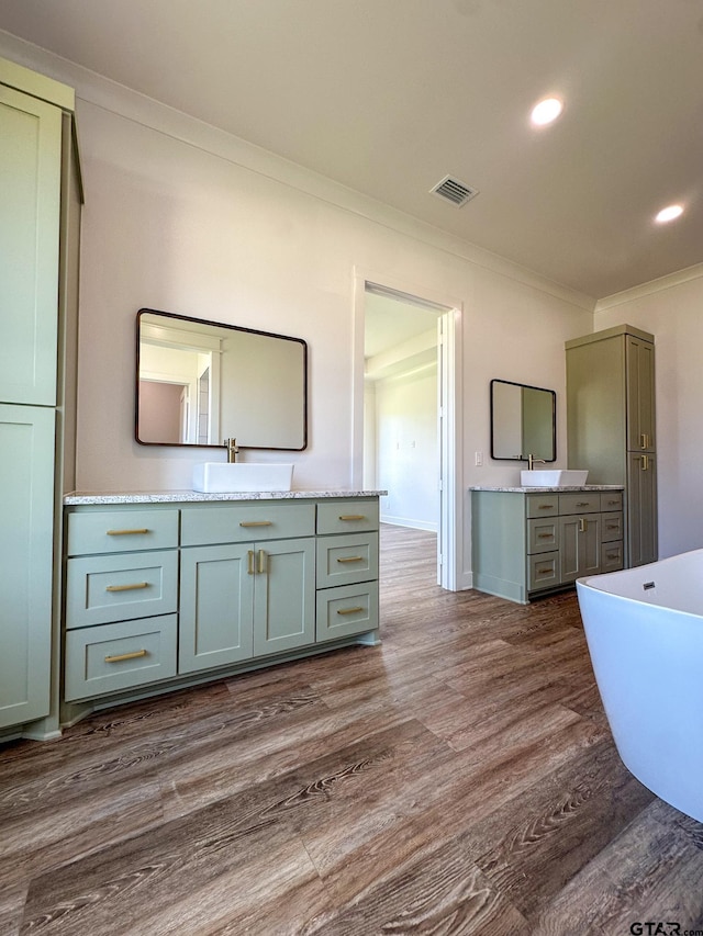 12301 Harlon, Flint, TX 75762 - full bathroom with ornamental molding, two vanities, a soaking tub, wood finished floors, and recessed lighting