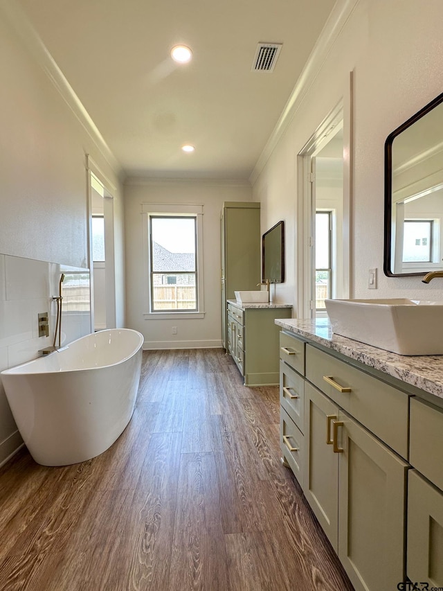 12301 Harlon, Flint, TX 75762 - bathroom featuring crown molding, wood finished floors, two vanities, a soaking tub, and recessed lighting
