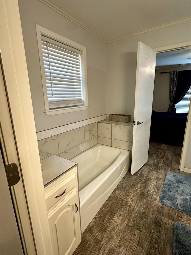 bathroom featuring a washtub, hardwood / wood-style floors, and ornamental molding