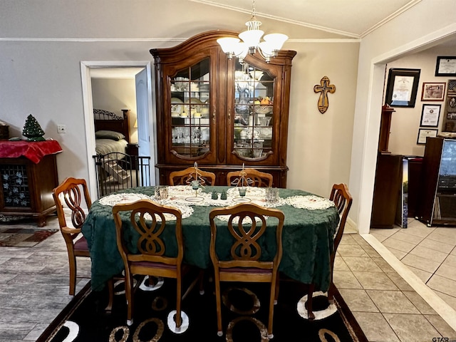 tiled dining room with a chandelier and ornamental molding