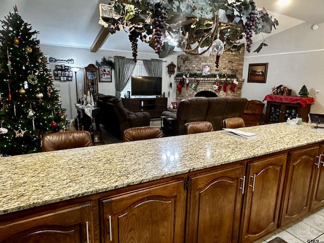 kitchen with light stone counters, a fireplace, and light tile patterned flooring