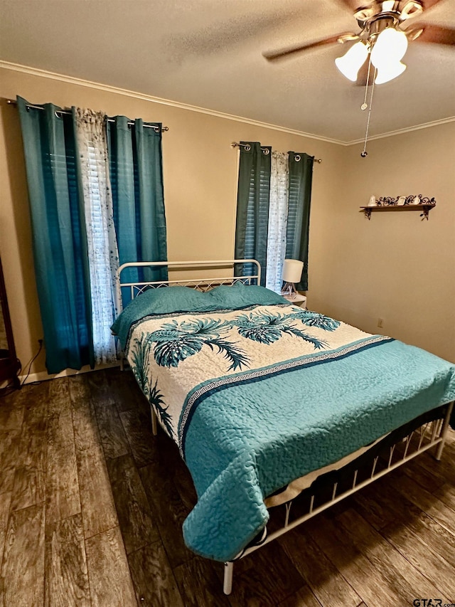 bedroom featuring hardwood / wood-style floors, ceiling fan, ornamental molding, and a textured ceiling