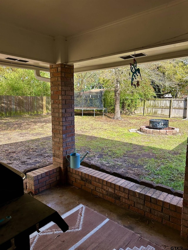 view of patio / terrace with a trampoline and a fire pit