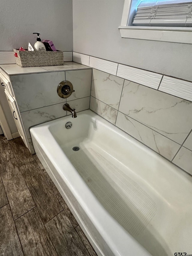 bathroom featuring a tub to relax in and hardwood / wood-style floors