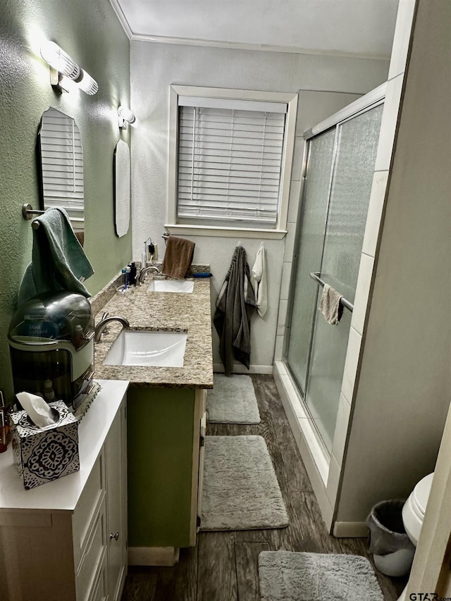 bathroom featuring hardwood / wood-style floors, vanity, an enclosed shower, and toilet