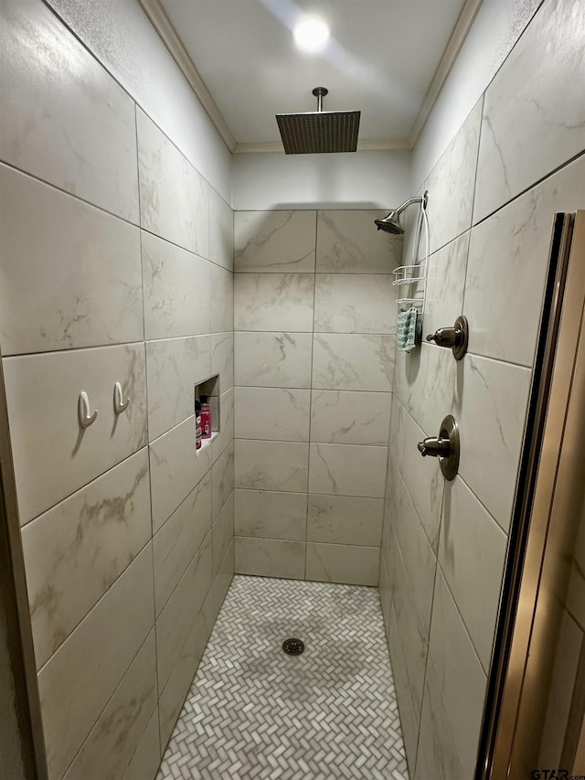 bathroom featuring a tile shower and ornamental molding