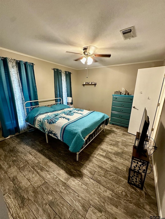 bedroom featuring hardwood / wood-style floors, a textured ceiling, ceiling fan, and crown molding