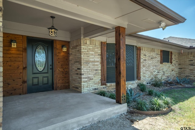 view of exterior entry featuring covered porch