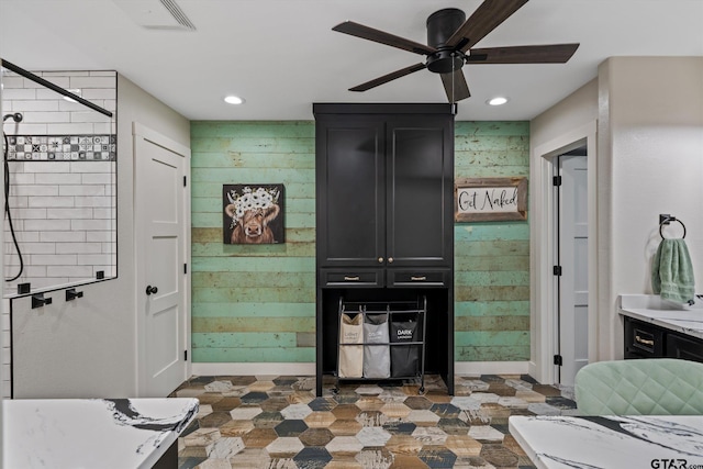 bathroom with vanity, ceiling fan, and a shower