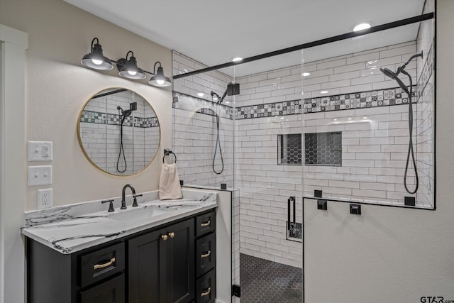 bathroom featuring a shower with door and vanity