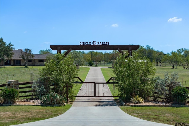 view of gate with a lawn