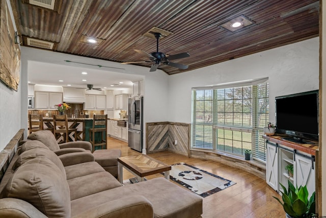 living room with light wood-type flooring, ceiling fan, and wooden ceiling