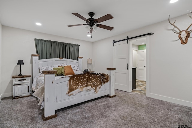 bedroom with carpet, a barn door, and ceiling fan