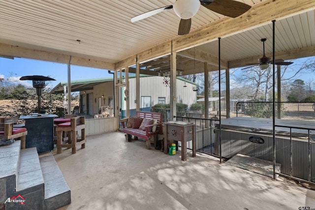 view of patio / terrace with a bar, a hot tub, and ceiling fan