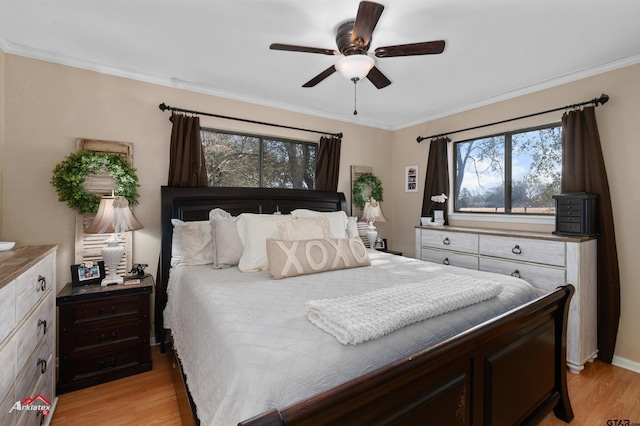 bedroom featuring crown molding, light hardwood / wood-style floors, and ceiling fan