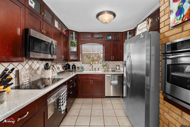 kitchen featuring sink, light tile patterned floors, appliances with stainless steel finishes, tasteful backsplash, and light stone counters