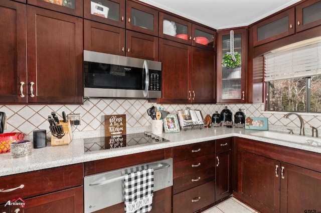 kitchen featuring black electric cooktop, light stone countertops, sink, and decorative backsplash