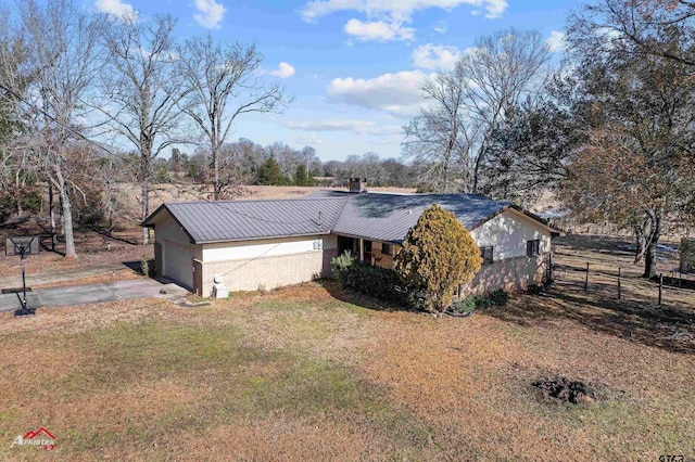 view of side of property featuring a garage and a yard