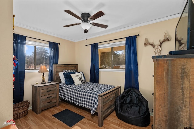 bedroom featuring ornamental molding, ceiling fan, and light wood-type flooring