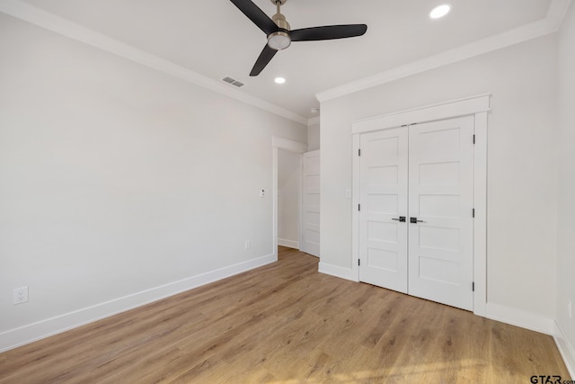 unfurnished bedroom featuring ceiling fan, a closet, light hardwood / wood-style flooring, and ornamental molding