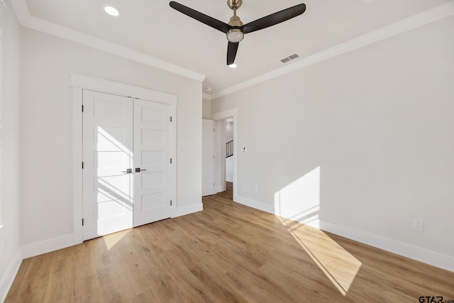 unfurnished bedroom featuring ceiling fan, a closet, light hardwood / wood-style flooring, and ornamental molding