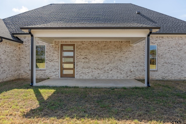 back of property with a lawn and a patio area